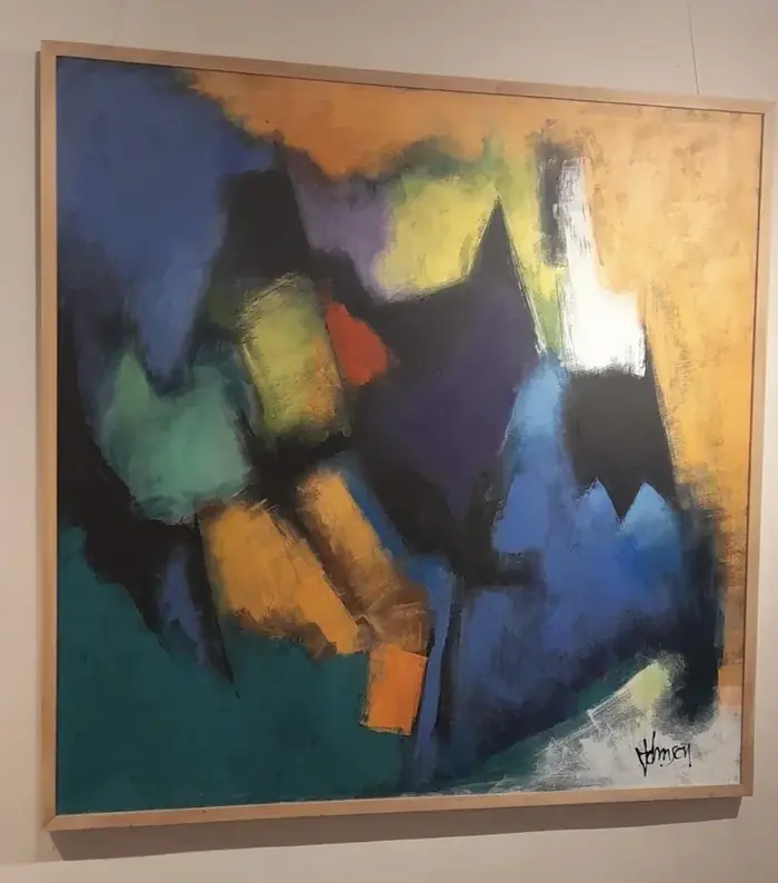 Painting with fields of color in blue, yellow, green and orange on a light wall