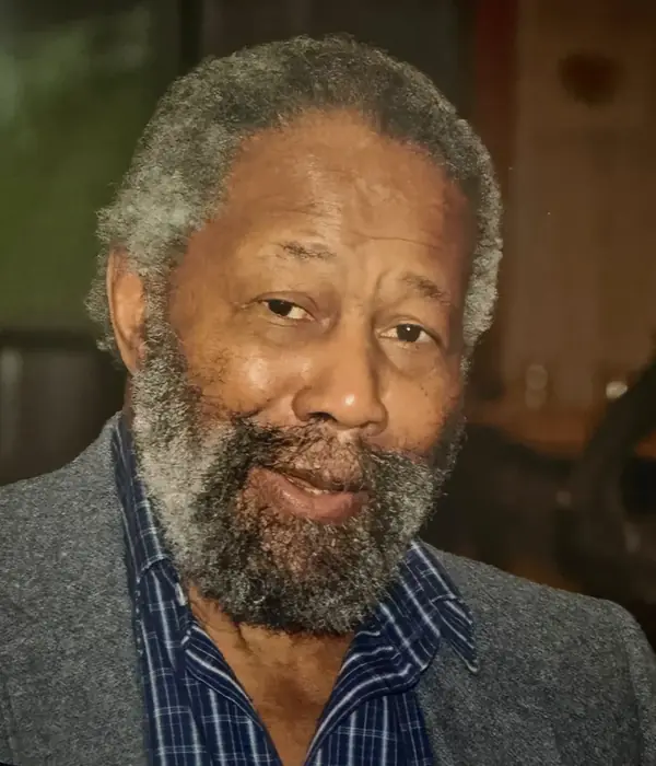 Ronald E. Johnson with a gray beard, in a gray jacket and blue checked shirt